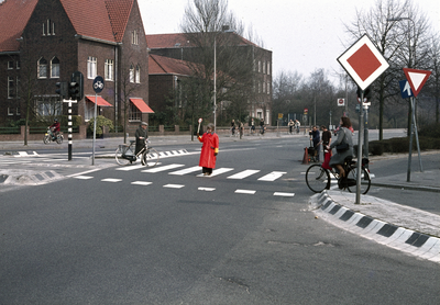 117537 Afbeelding van een verkeersbrigadier bij de oversteekplaats voor voetgangers op de hoek van de Spinozaweg ...